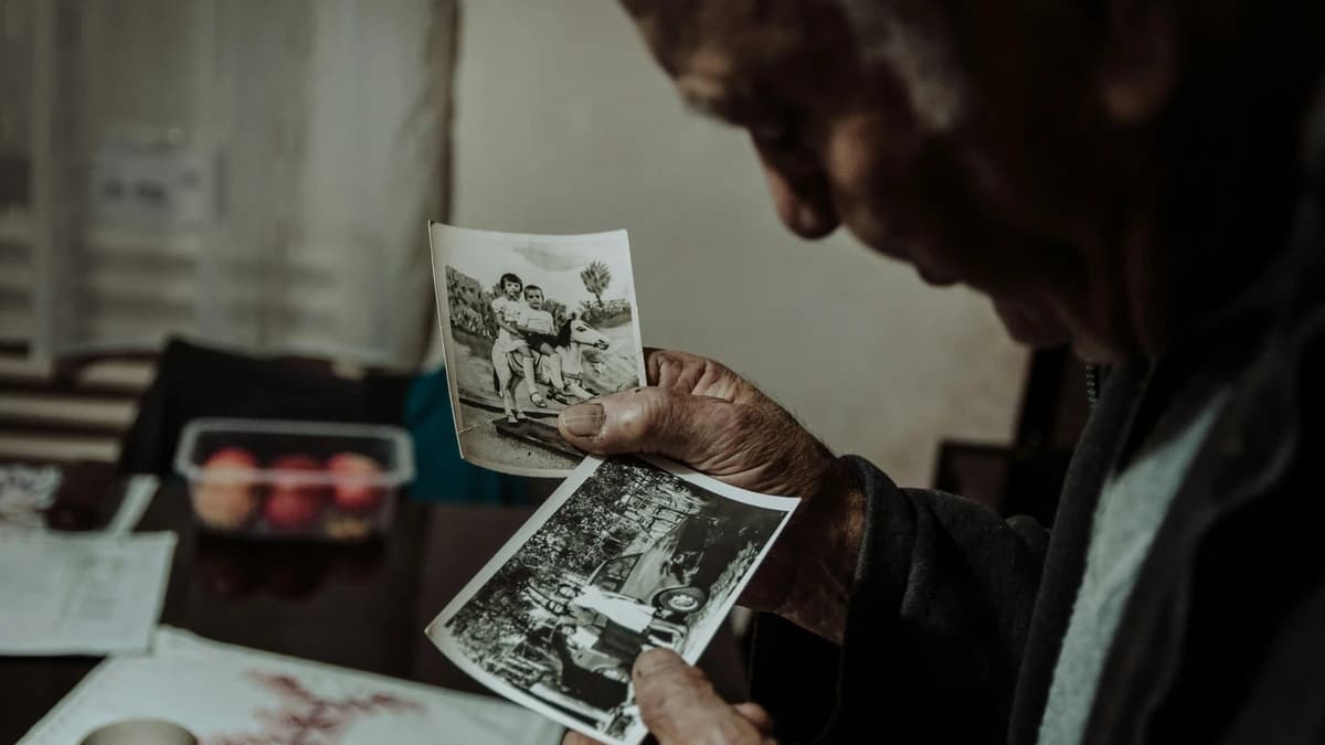 An elderly man sorting old family photographs