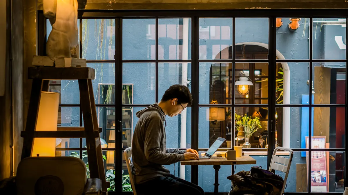 A freelancer working a shot list on a laptop in a cafe