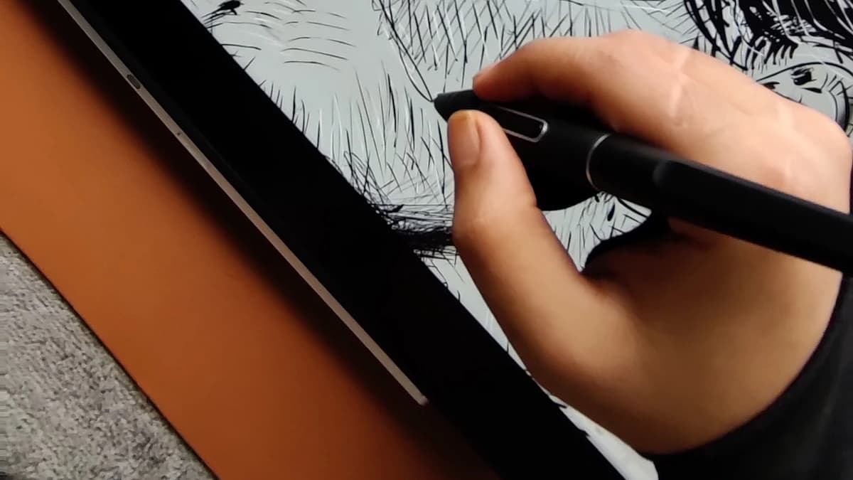 An artist inking a concept board on a pen tablet