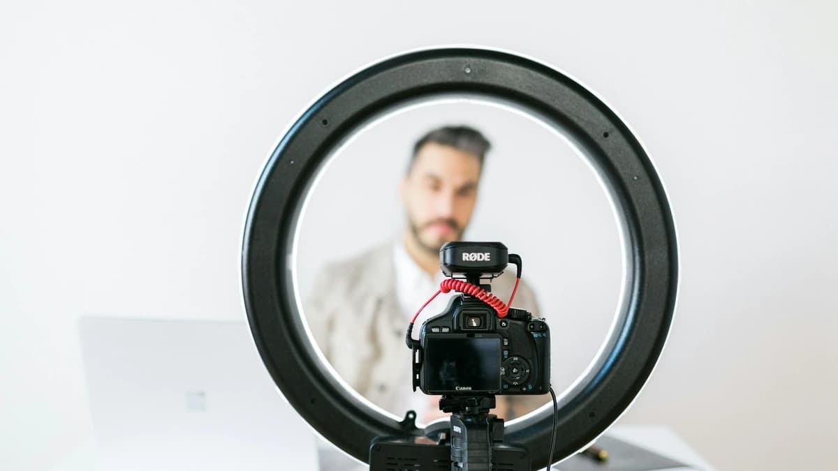 A creator framed behind a ring light and camera