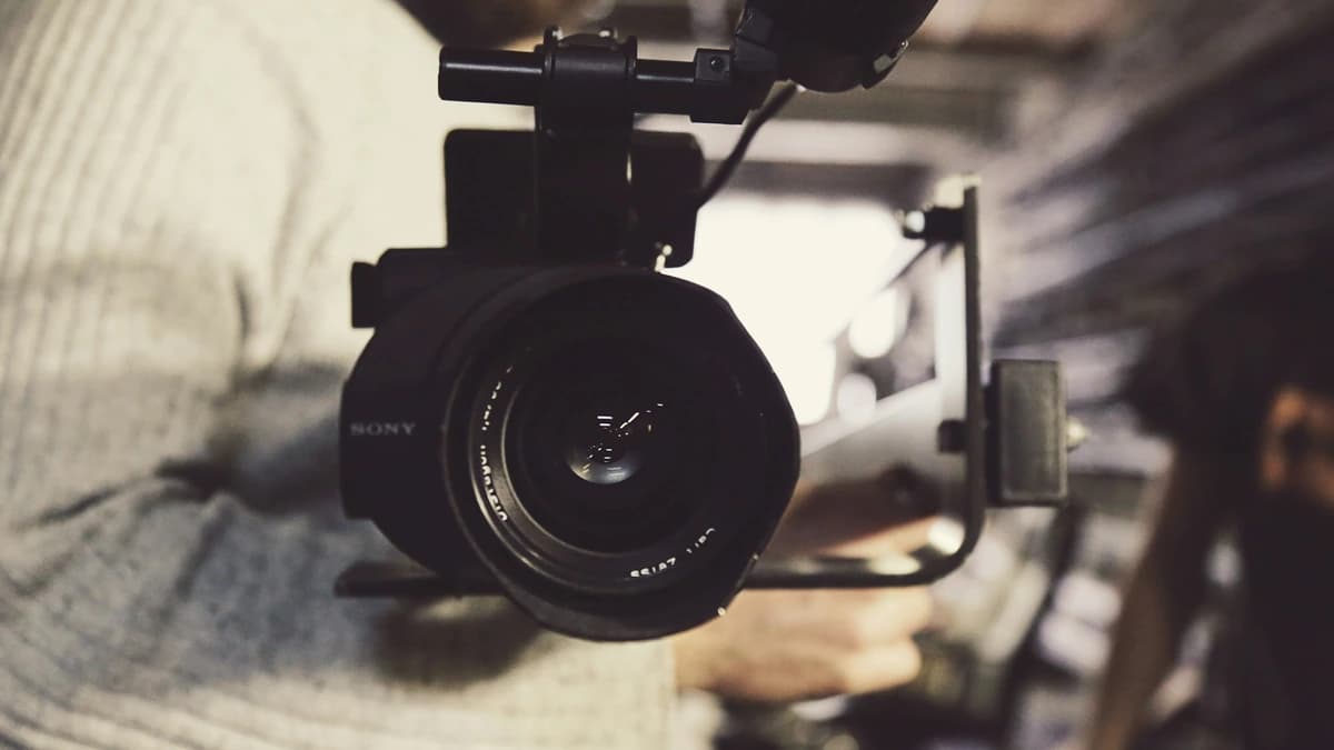 A camera operator carrying a cinema camera