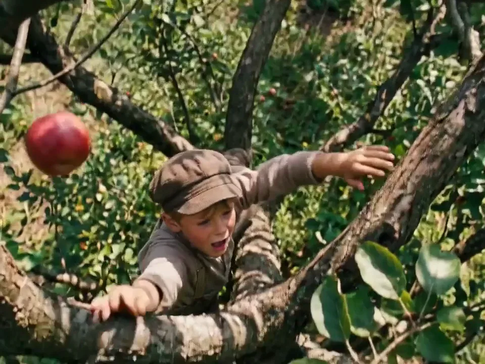 An apple dropping through branches as the camera follows it down in a Kling AI take